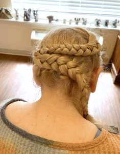 A photograph of the back of a blonde woman's head shows two elaborate braids.