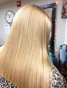 The back of a blonde woman's head can be seen as she shows off her fresh haircut and color treatment. 