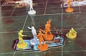 Small plastic character figures are clustered together on the playing board of Last Night On Earth, a zombie apocalypse game.