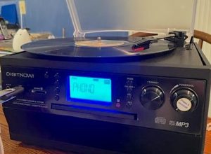 The DigiNow MP3 converter features what looks like a standard record player on top, but with a digital display below and a slot for inserting a thumb drive.