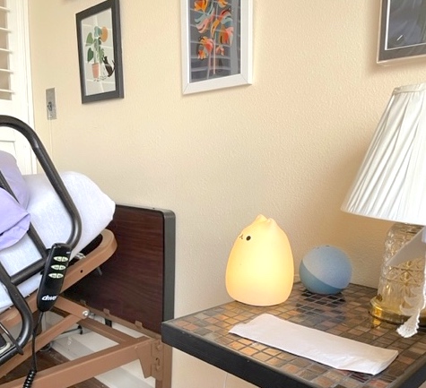 A freestanding, cat-shaped nightlight glowing from within sits on a tiled nightstand.
