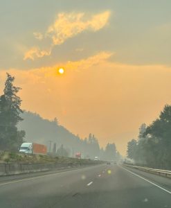 Over a California highway, the daytime sky is a dense, hazy orange.